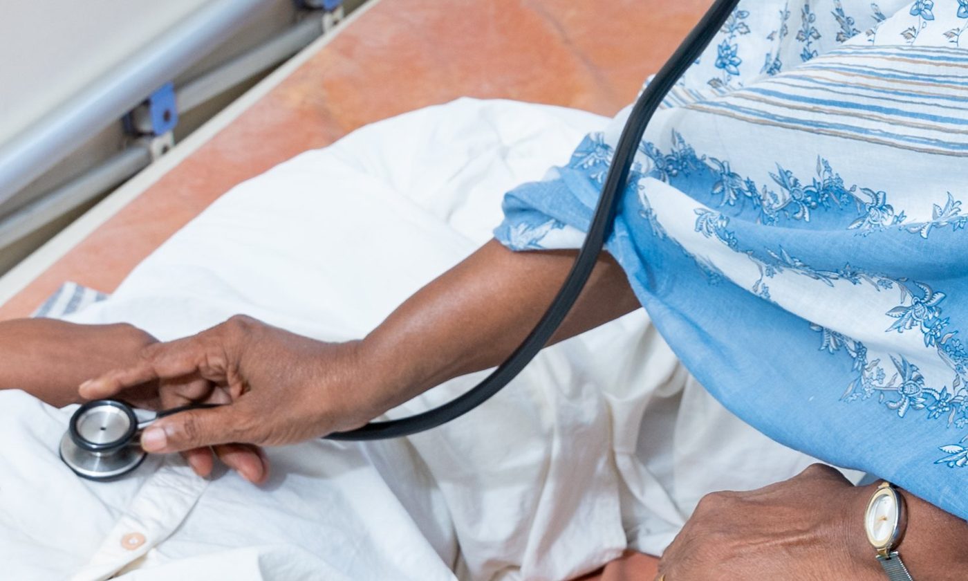A doctor listening to a patient's chest with a stethoscope