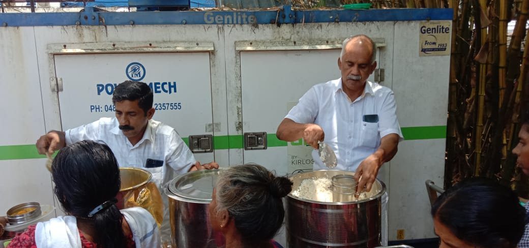 Mr. Peter and a volunteer serving lunch to bystanders