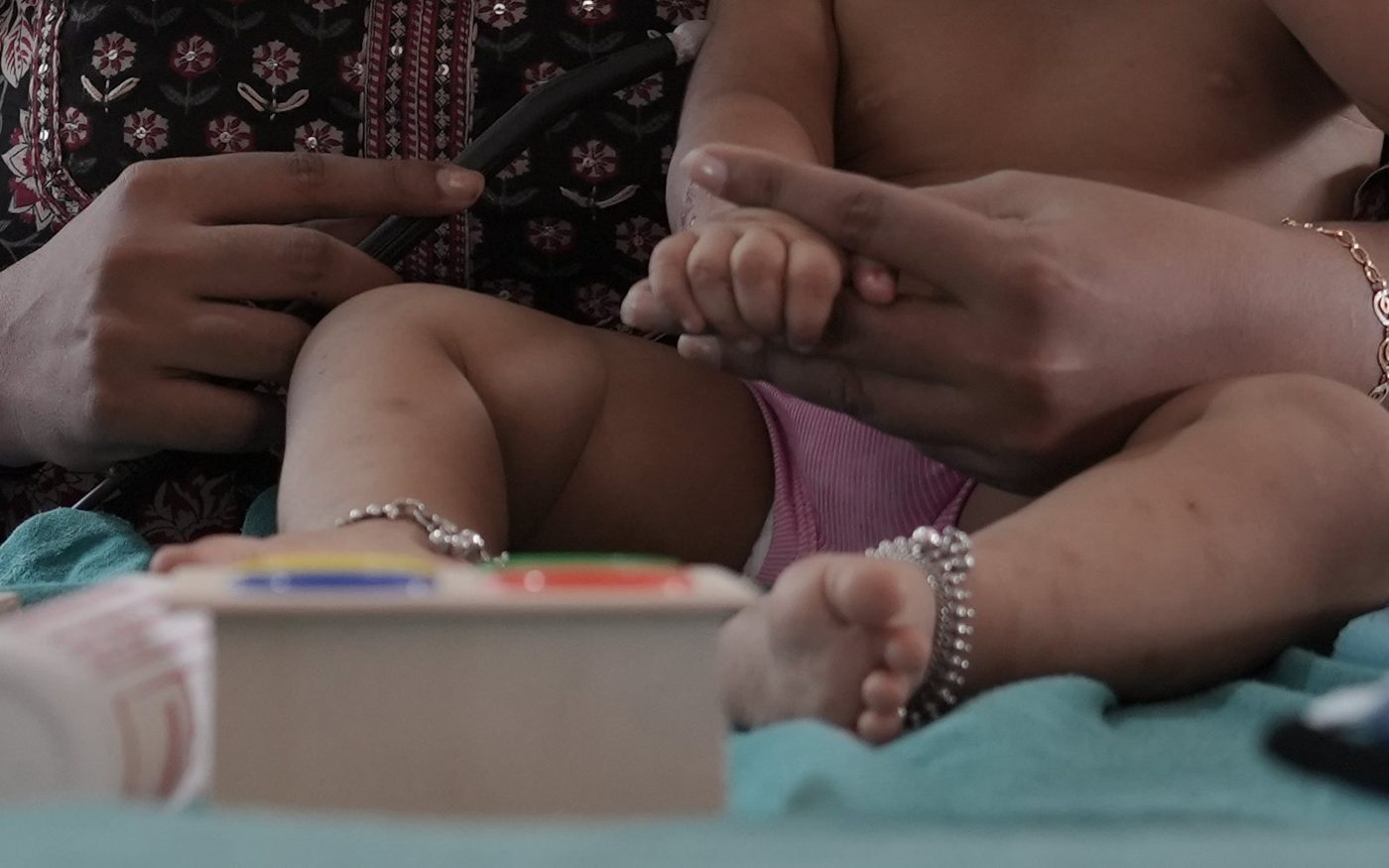A physiotherapist working with a baby's arm